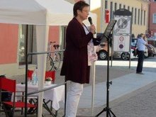 Dr. KathrinWahlbuhl-Nitsche, Leiterin der Freien Schule im  Burgenland „Jan Hus“, liest von Sophia Müller, einer Schülerin ihrer Schule, die Geschichte „Das kleine Mädchen mit den roten Schuhen“, geschrieben nach deren Besuch des ehemal. KZ Aus